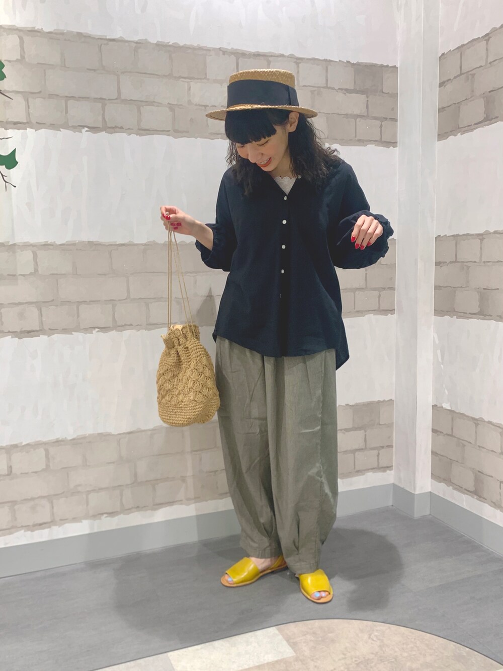 イエロー系のサンダル、ベージュ系のエコバッグ/サブバッグ、ホワイト系のTシャツ/カットソーを着用したレディースの春コーディネートの2枚目の写真