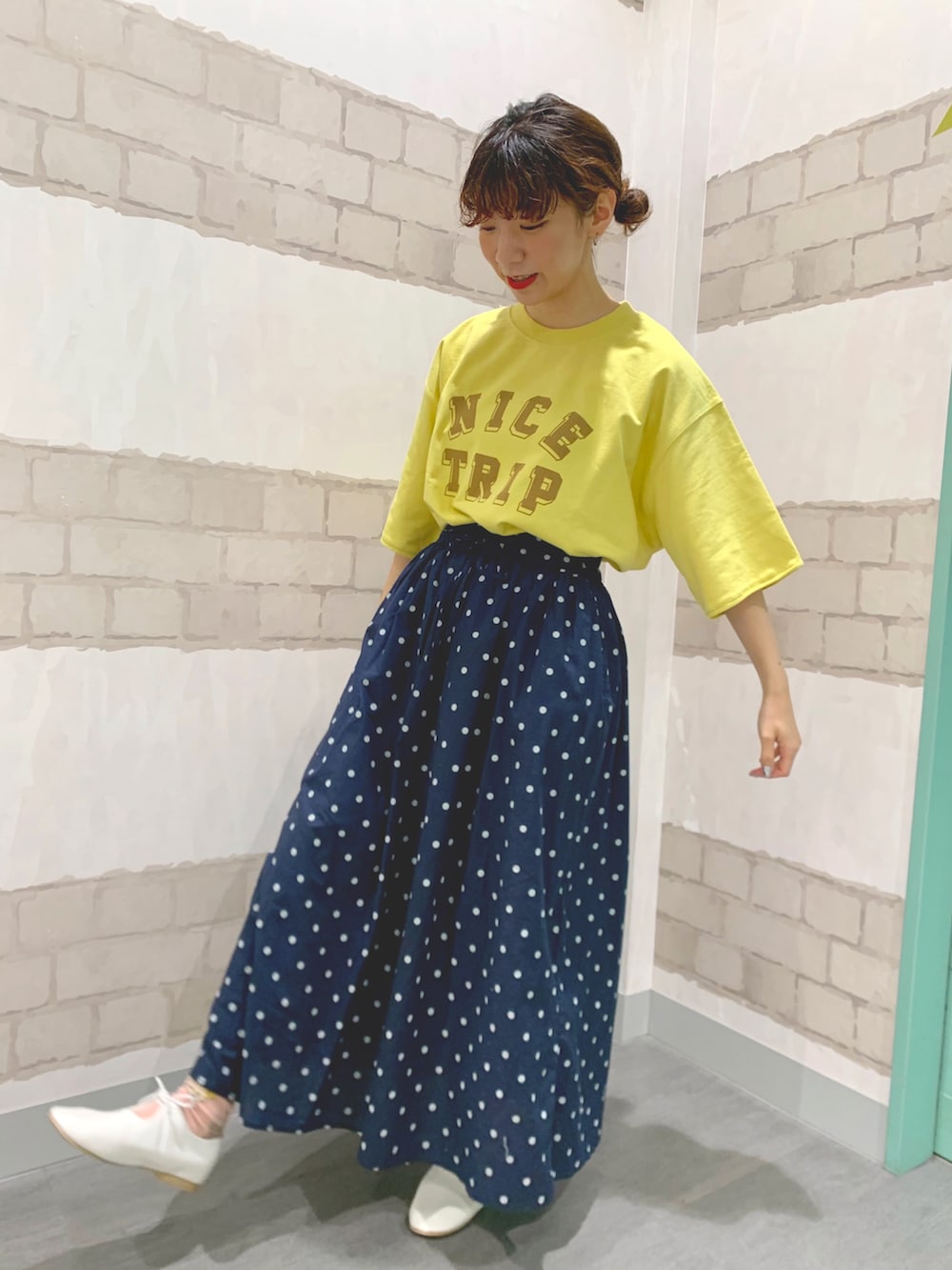 イエロー系のトートバッグ、イエロー系のTシャツ/カットソー、ホワイト系のマウンテンパーカーを着用したレディースの春コーディネートの3枚目の写真