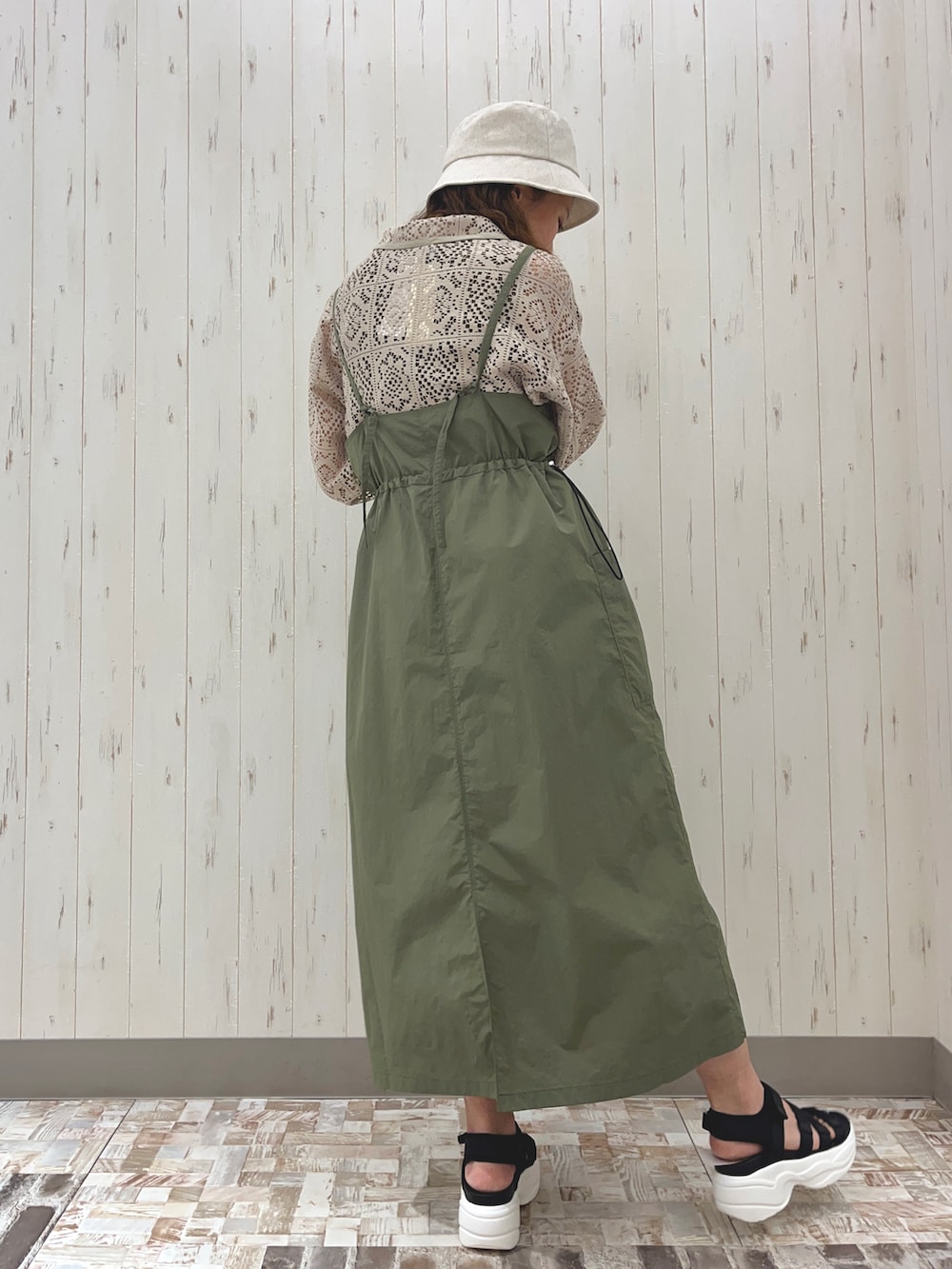 ブラック系のサンダル、グリーン系のワンピース、ベージュ系のシャツ/ブラウスを着用したレディースの春コーディネートの2枚目の写真