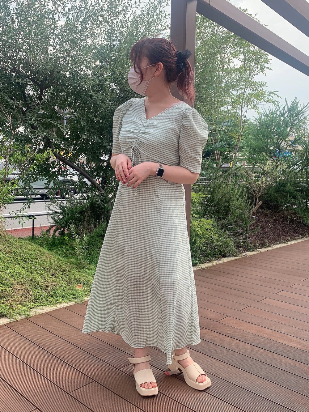 グリーン系のワンピース、ホワイト系のシャツ/ブラウス、ホワイト系のサンダルを着用したレディースの夏コーディネートの3枚目の写真