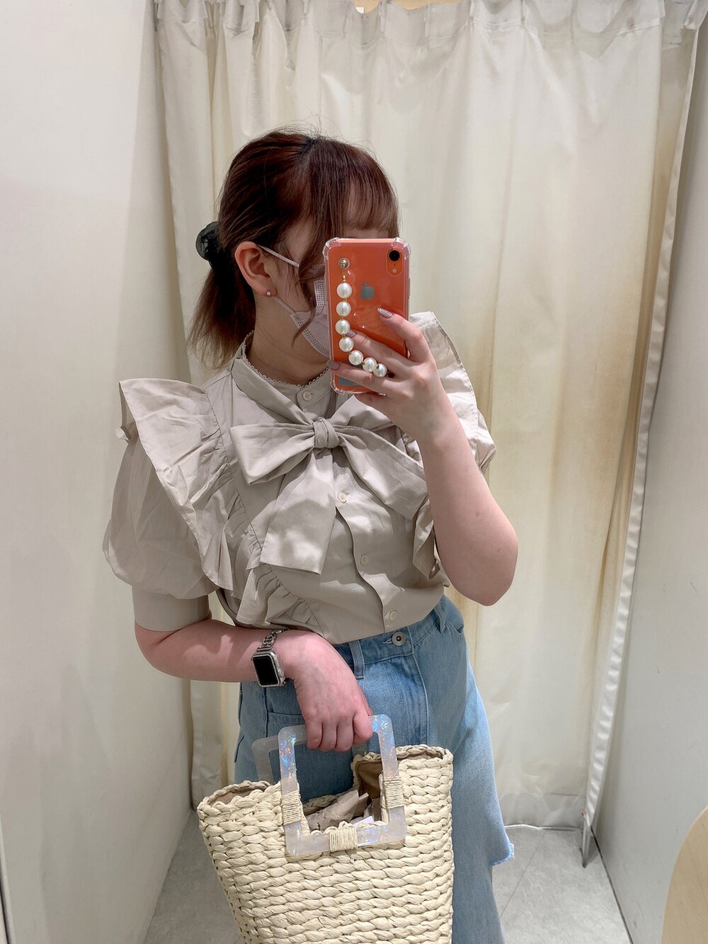 ベージュ系のシャツ/ブラウス、ベージュ系のかごバッグ、ブルー系のデニムパンツを着用したレディースの夏コーディネートの2枚目の写真