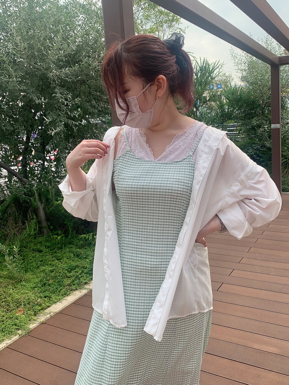 グリーン系のワンピース、ホワイト系のシャツ/ブラウス、ホワイト系のサンダルを着用したレディースの夏コーディネートの2枚目の写真