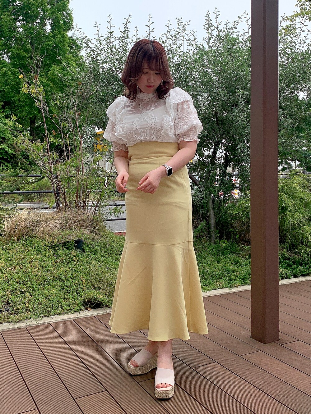 ホワイト系のシャツ/ブラウス、イエロー系のスカート、ホワイト系のサンダルを着用したレディースの春コーディネートの2枚目の写真