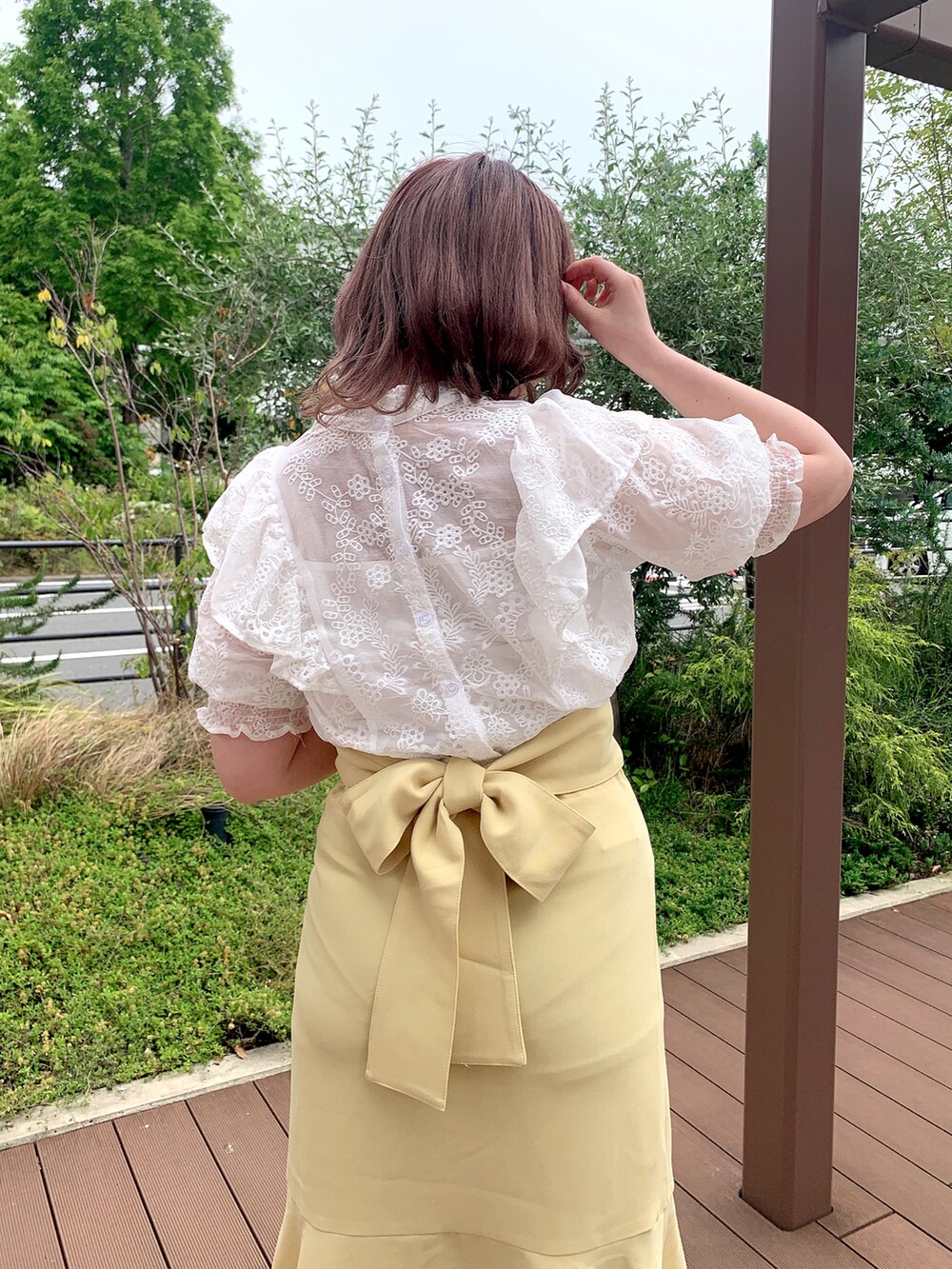 ホワイト系のシャツ/ブラウス、イエロー系のスカート、ホワイト系のサンダルを着用したレディースの春コーディネートの3枚目の写真