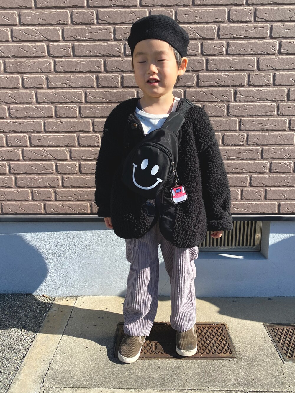 ホワイト系のノーカラージャケット、ホワイト系のサロペット/オーバーオール、グレー系のスリッポンを着用したキッズの春コーディネートの2枚目の写真