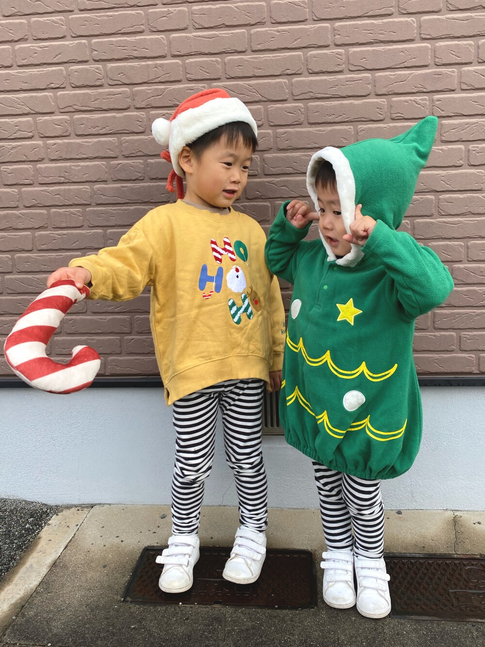 イエロー系のスウェット、ブラック系のパンツ、ホワイト系のスニーカーを着用したキッズの冬コーディネートの2枚目の写真