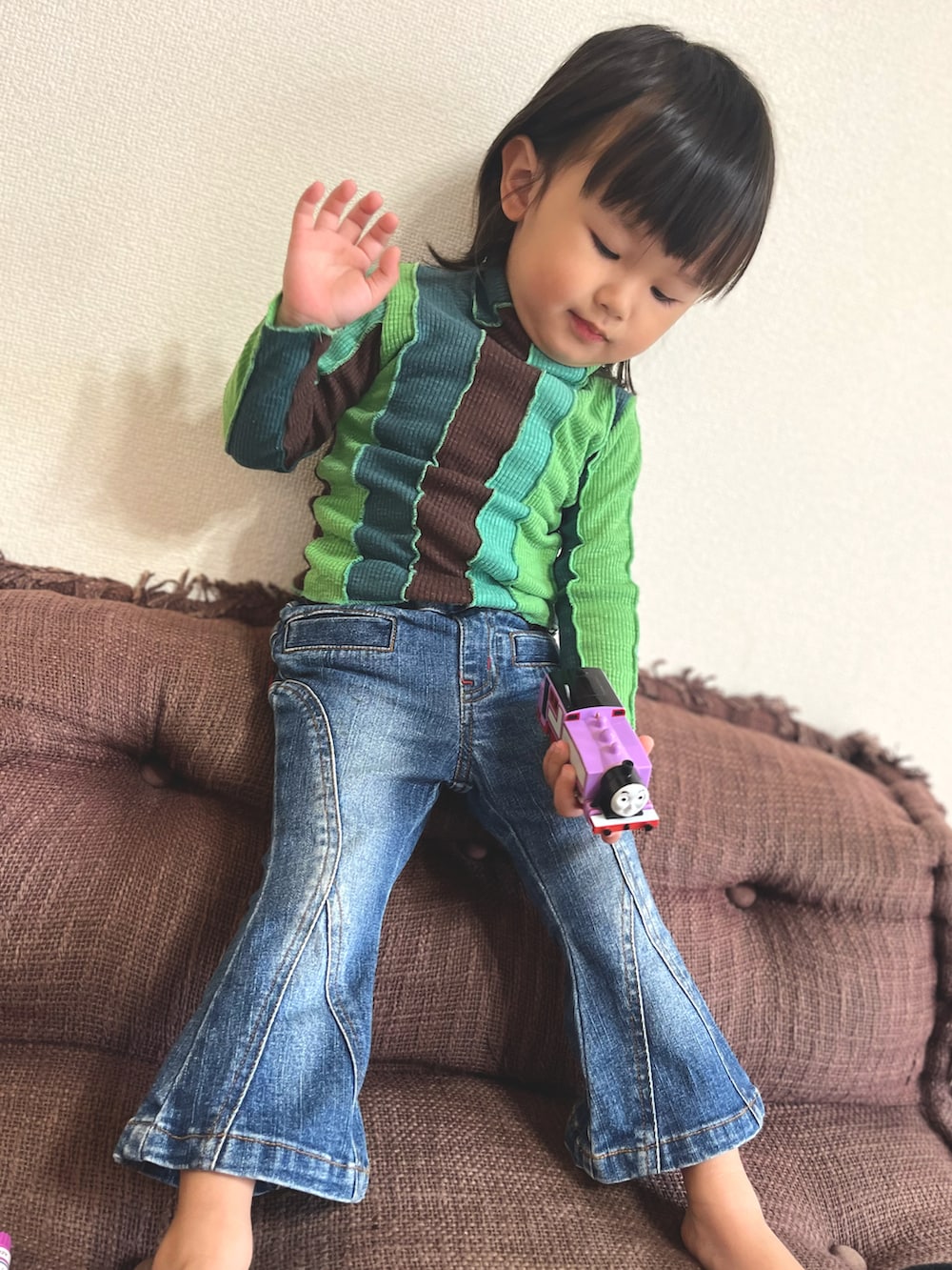 ブルー系のデニムパンツ、グリーン系のトップスを着用したキッズの秋コーディネートの3枚目の写真