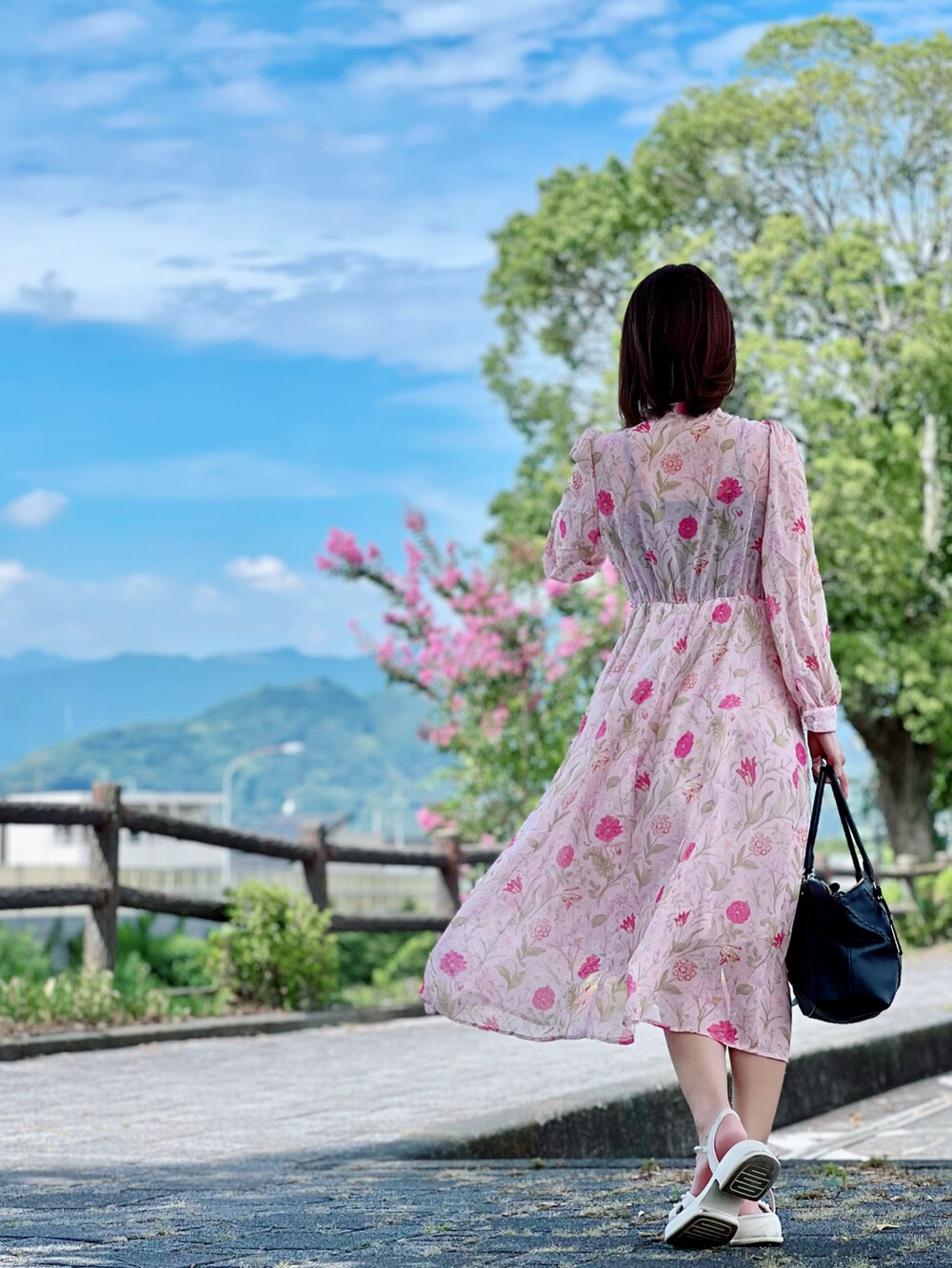 ピンク系のワンピースを着用したレディースの秋コーディネートの2枚目の写真