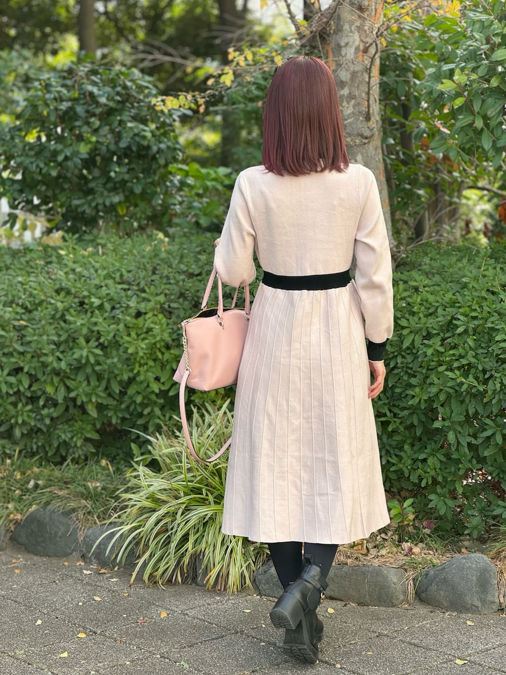 ピンク系のワンピース/ドレス、ピンク系のバッグを着用したレディースの冬コーディネートの2枚目の写真