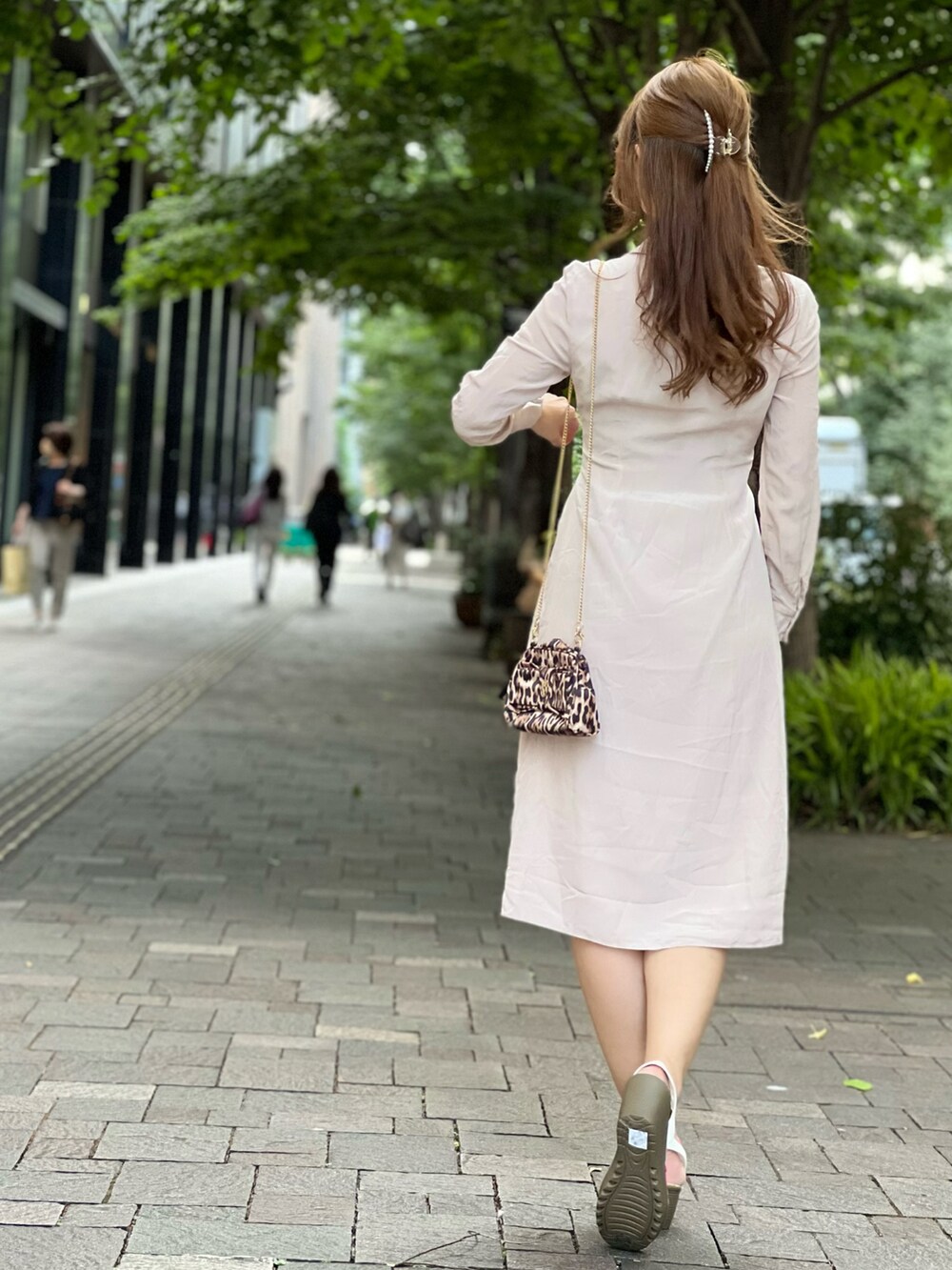 ゴールド系のショルダーバッグ、ベージュ系のワンピース/ドレスを着用したレディースの夏コーディネートの2枚目の写真