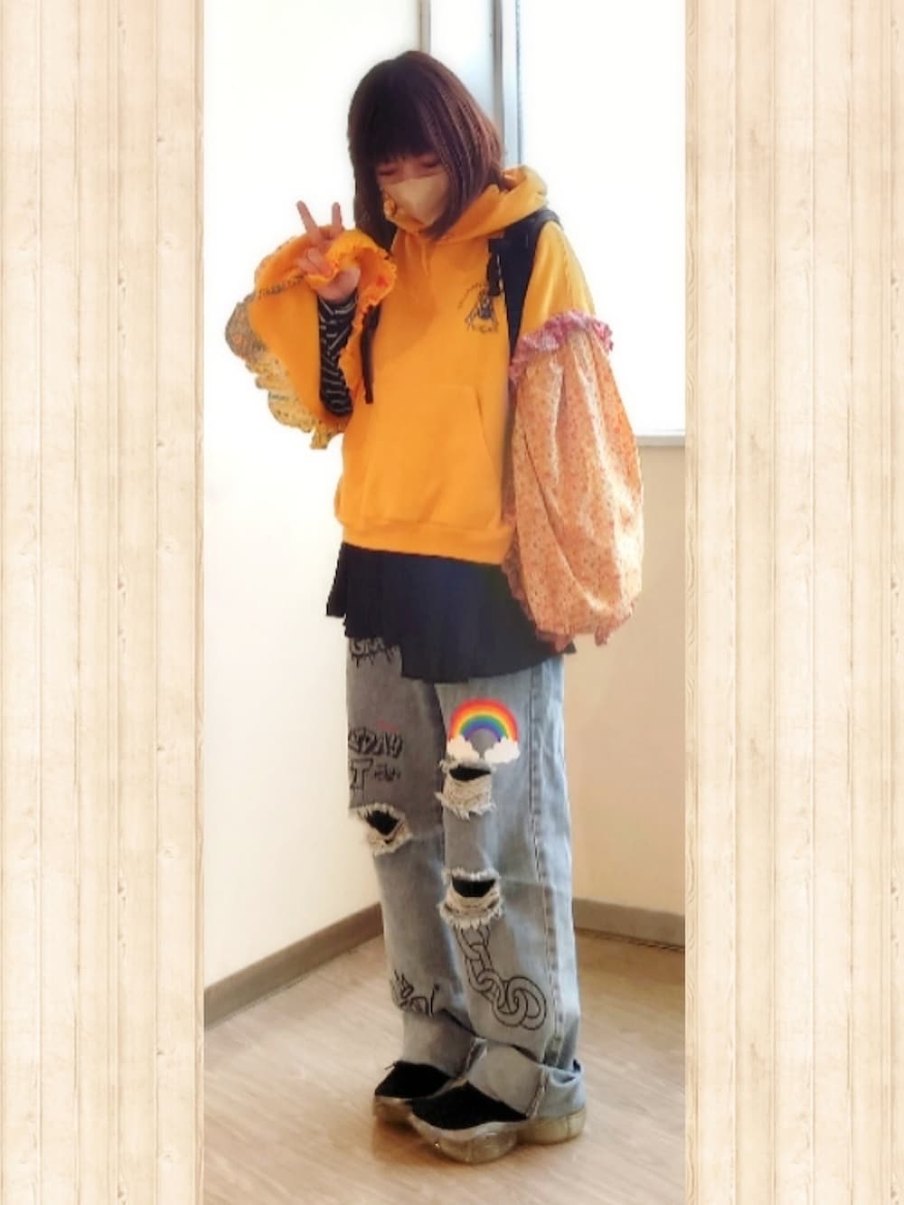 イエロー系のパーカー、ブルー系のデニムパンツ、ブラック系のバックパック/リュックを着用したレディースの夏コーディネートの2枚目の写真