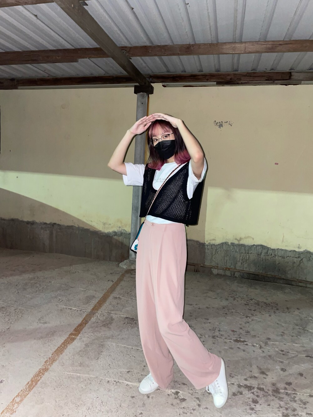 ピンク系のスラックス、ブラック系のトップス、ホワイト系のTシャツ/カットソーを着用したレディースの夏コーディネートの2枚目の写真