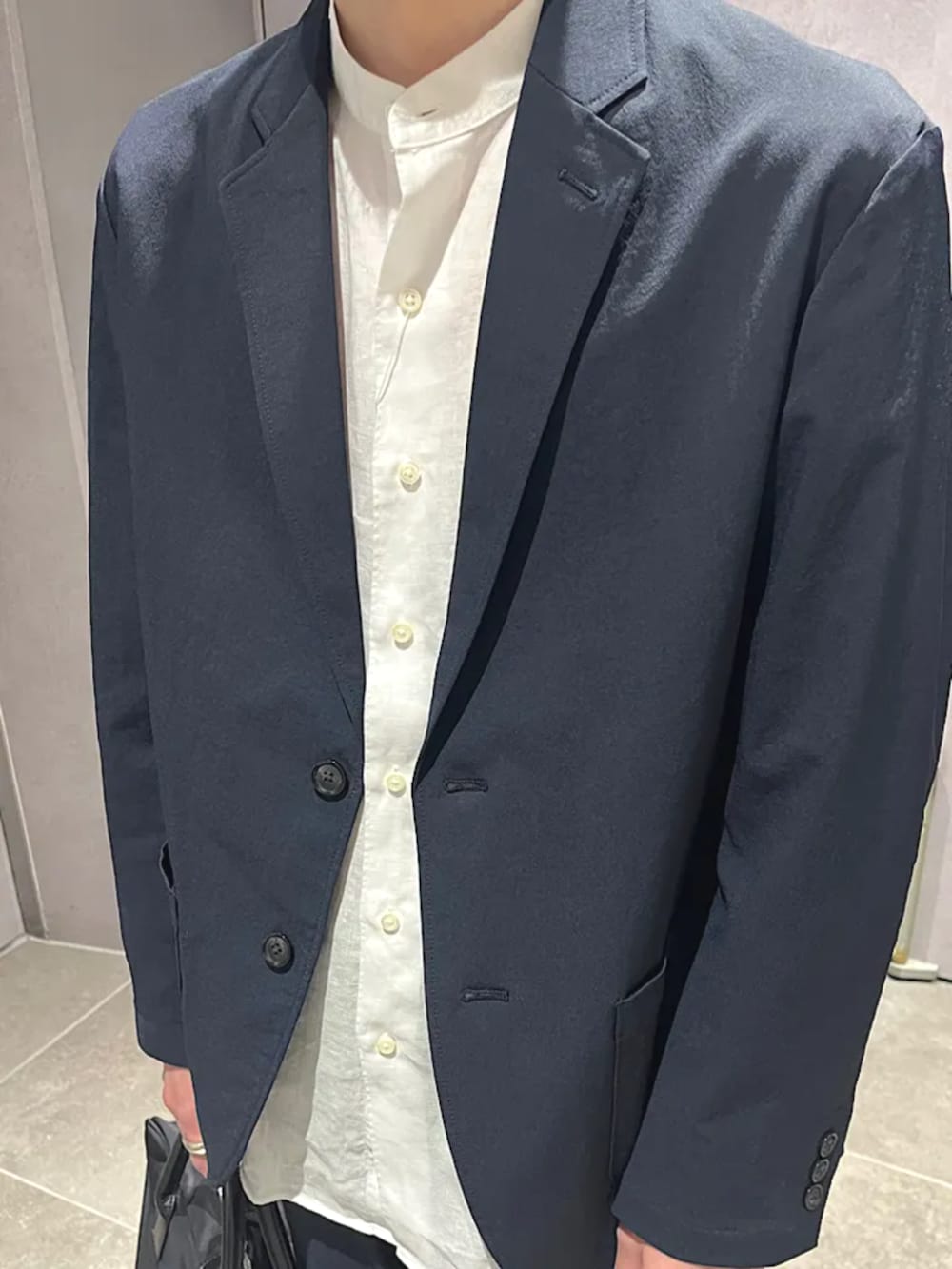 ブルー系のテーラードジャケット、ブルー系のその他パンツ、ブラック系のビジネスバッグを着用したメンズの夏コーディネートの3枚目の写真
