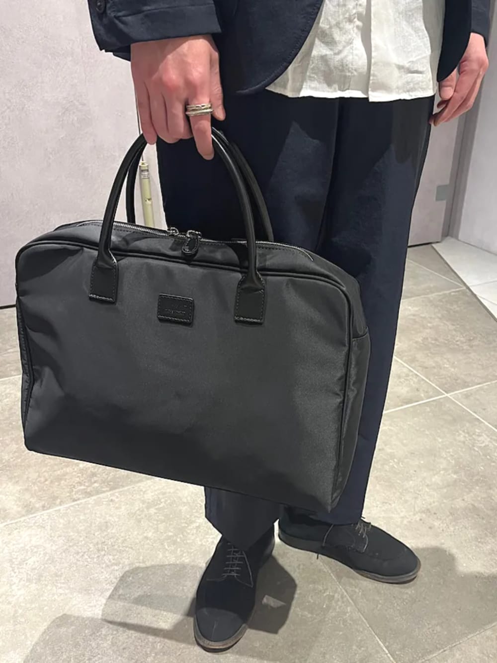 ブルー系のテーラードジャケット、ブルー系のその他パンツ、ブラック系のビジネスバッグを着用したメンズの夏コーディネートの2枚目の写真