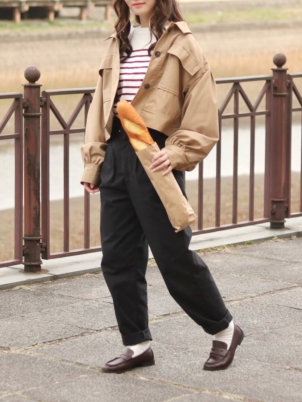 レッド系のTシャツ/カットソー、ベージュ系のその他アウター、ブラック系のデニムパンツを着用したレディースの春コーディネートの2枚目の写真
