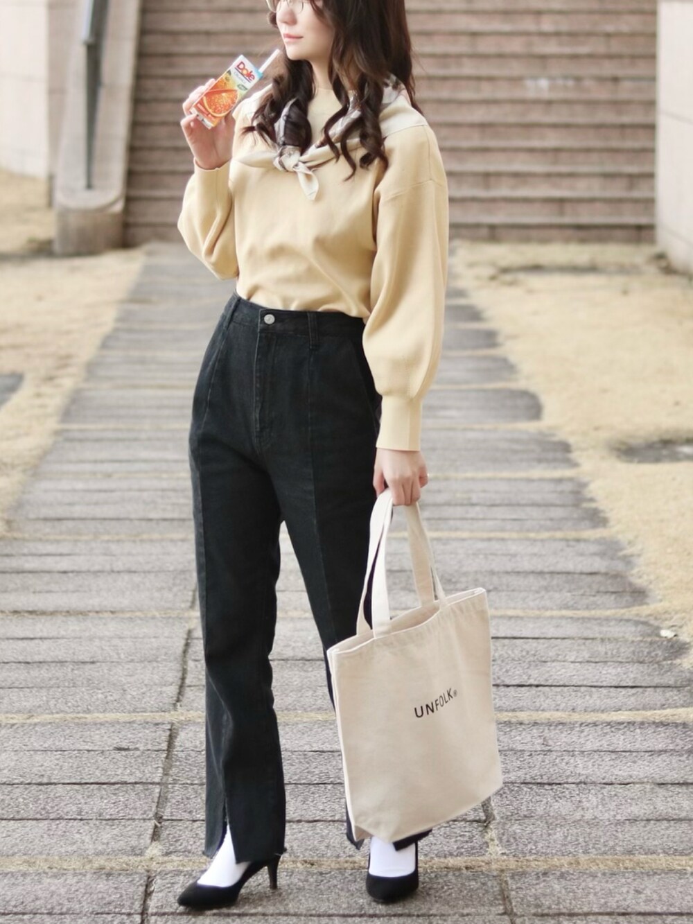 ホワイト系のニット/セーター、ブラック系のデニムパンツ、ホワイト系のトートバッグを着用したレディースの秋コーディネートの2枚目の写真
