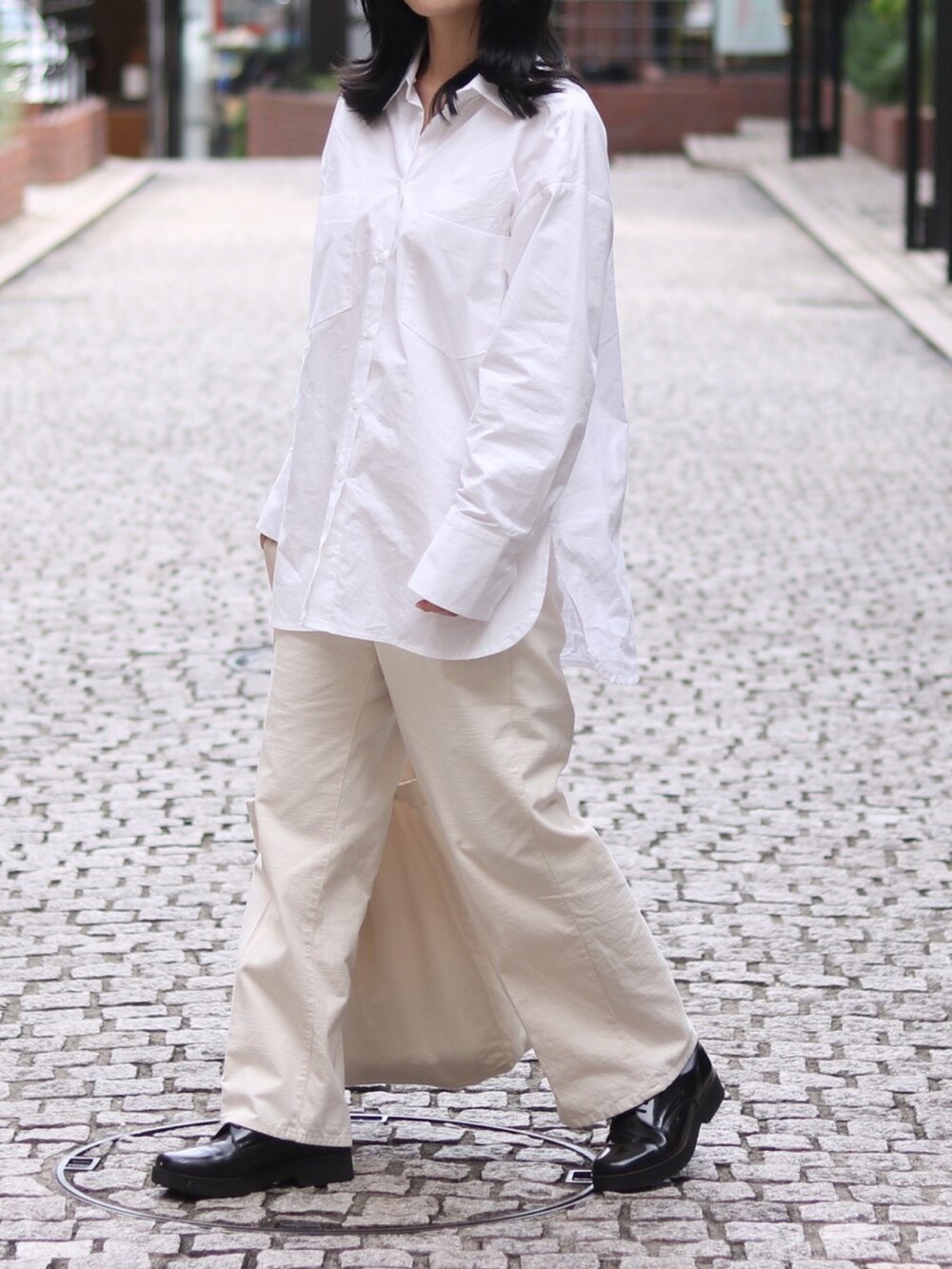 ホワイト系のシャツ/ブラウス、ホワイト系のスラックス、ホワイト系のトートバッグを着用したレディースの秋コーディネートの2枚目の写真