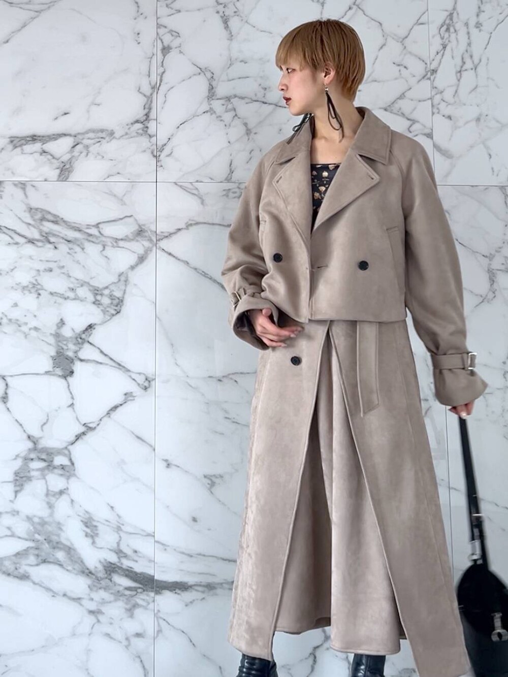 グレー系のブーツ、ブルー系のショルダーバッグ、ベージュ系のスカートを着用したレディースの夏コーディネートの2枚目の写真