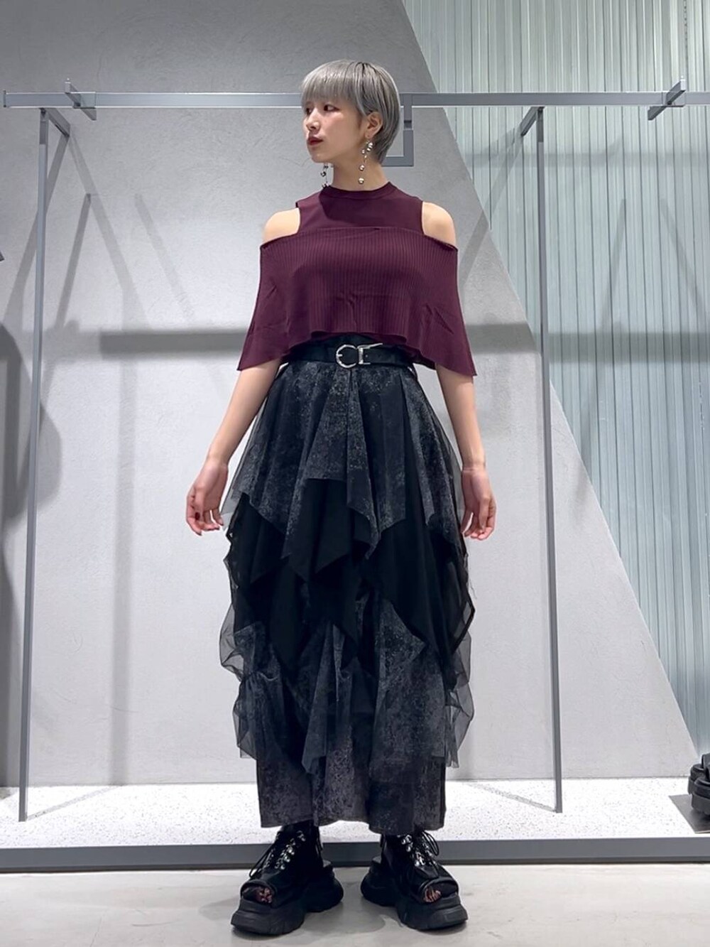 ブラック系のサンダル、レッド系のTシャツ/カットソー、グレー系のスカートを着用したレディースの夏コーディネートの2枚目の写真