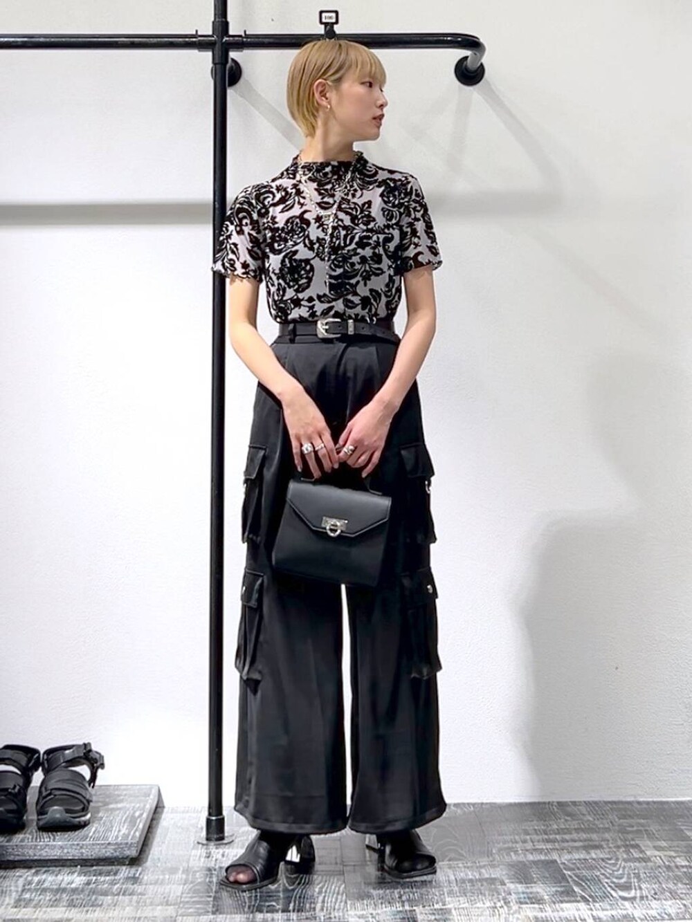 ブラック系のカーゴパンツ、ブラック系のショルダーバッグ、ブラック系のサンダルを着用したレディースの春コーディネートの2枚目の写真