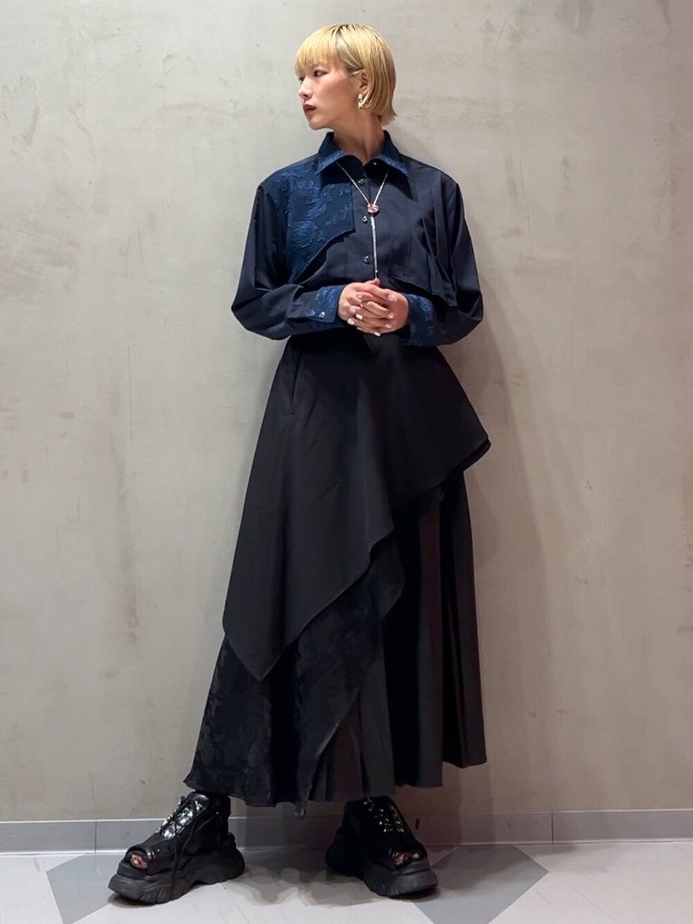 ブラック系のスカート、ブルー系のシャツ/ブラウス、シルバー系のネックレスを着用したレディースの秋コーディネートの2枚目の写真