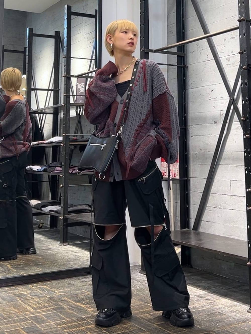 レッド系のカーディガン/ボレロ、ブラック系のカーゴパンツ、ブラック系のスニーカーを着用したレディースの秋コーディネートの5枚目の写真