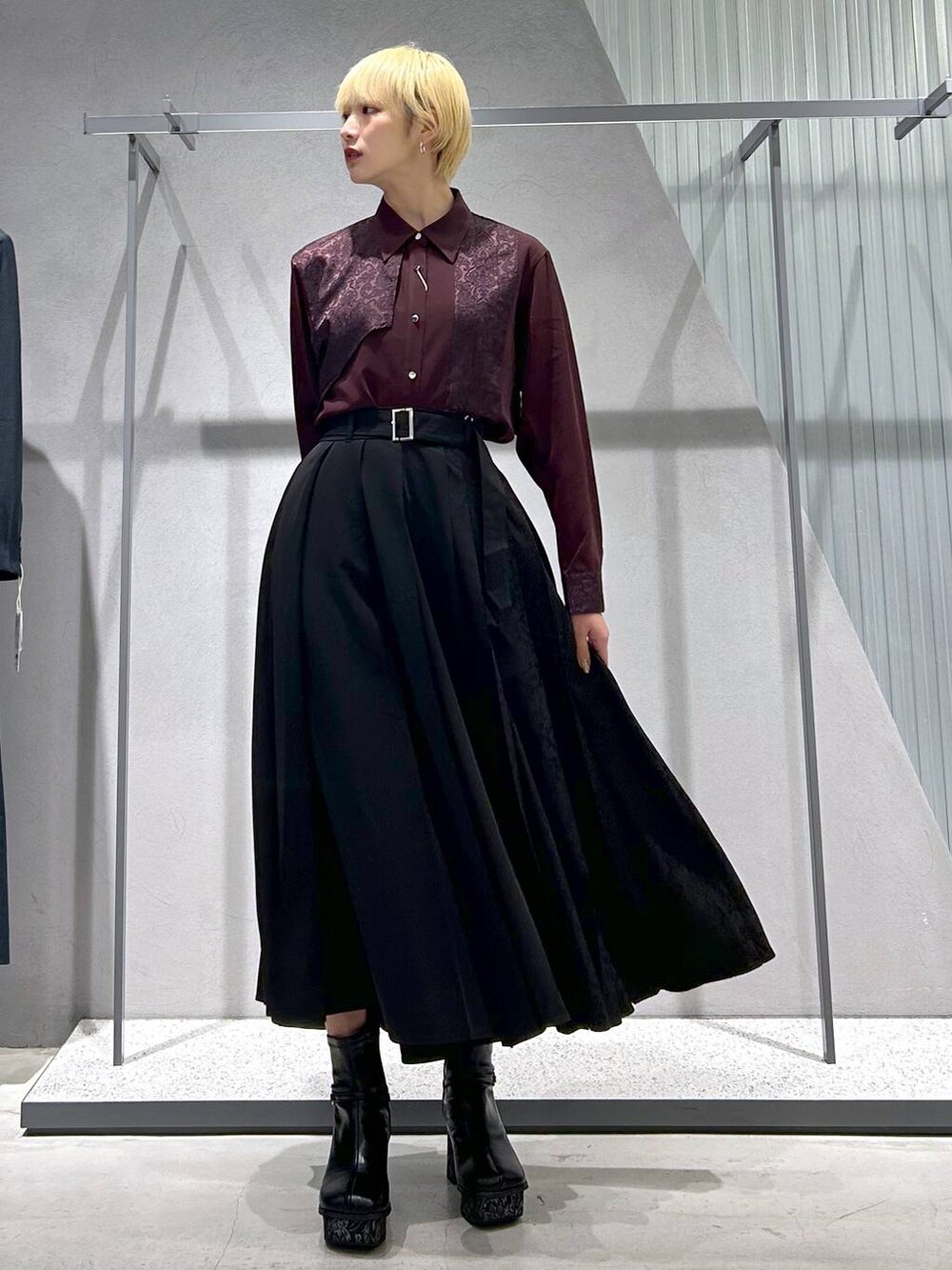 グレー系のブーツ、レッド系のシャツ/ブラウス、ブラック系のスカートを着用したレディースの秋コーディネートの3枚目の写真