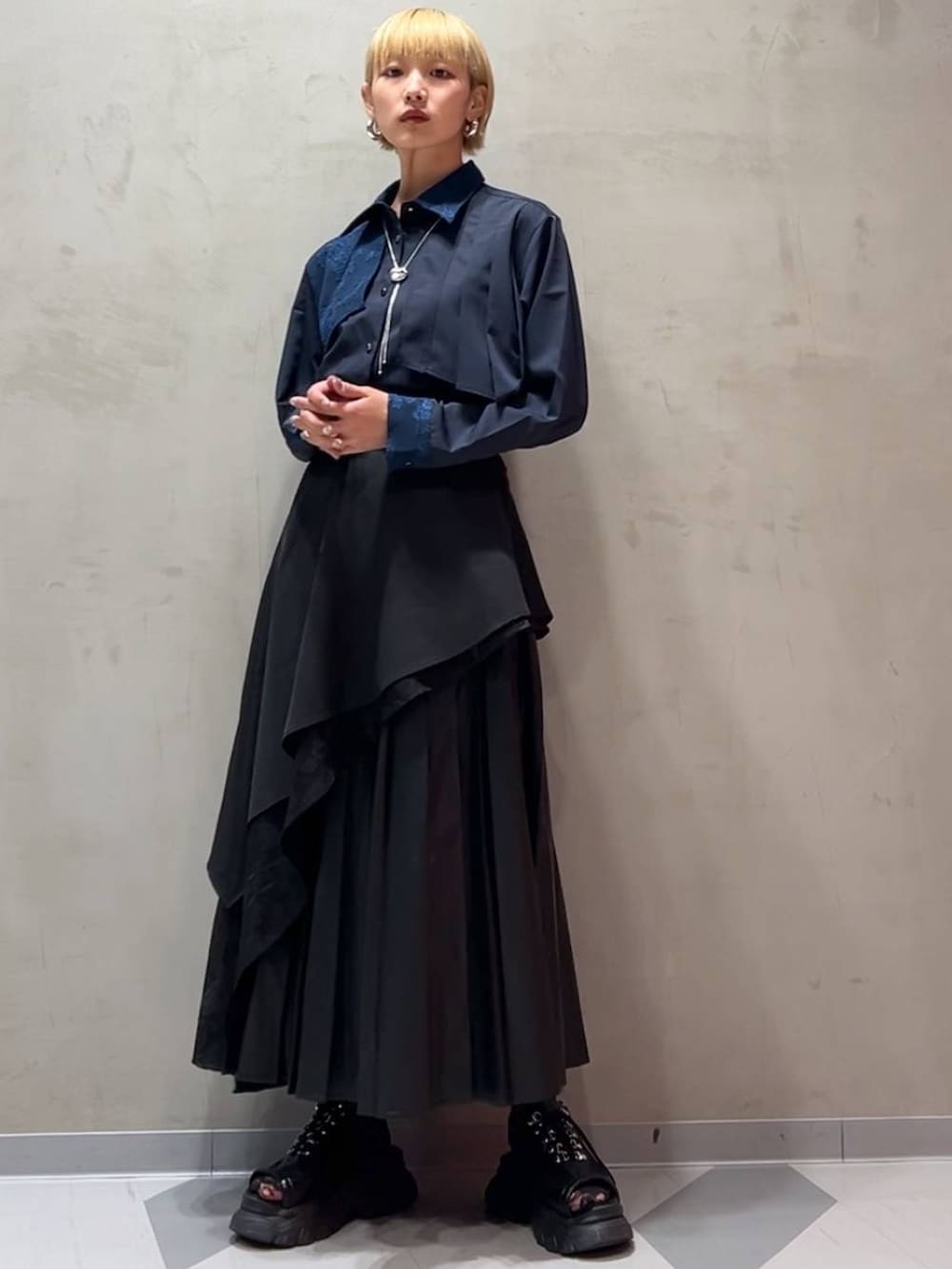 ブラック系のスカート、ブルー系のシャツ/ブラウス、シルバー系のネックレスを着用したレディースの秋コーディネートの5枚目の写真