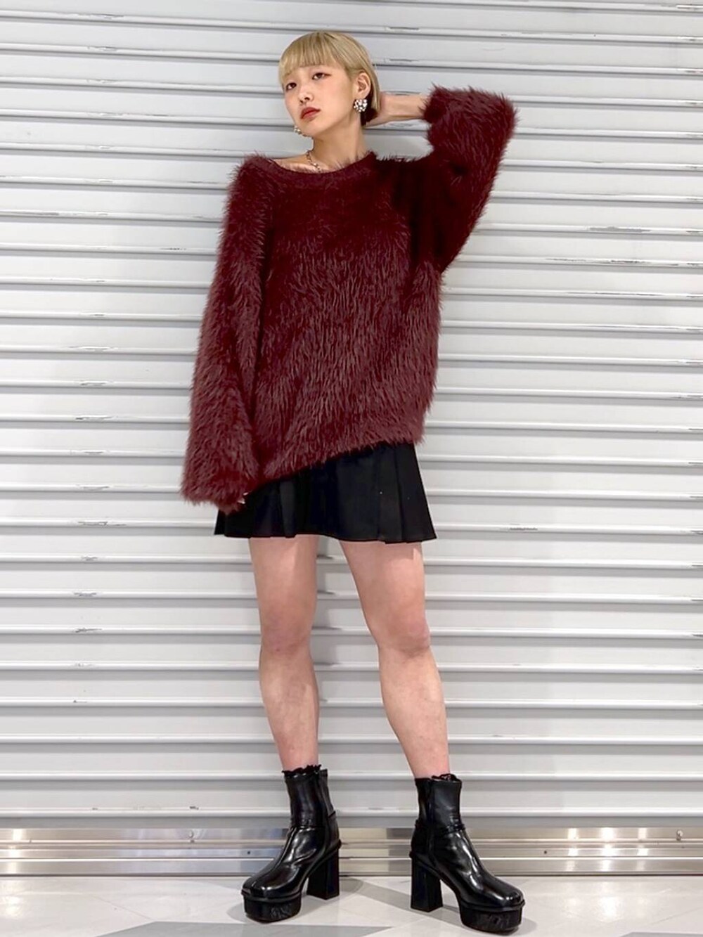 レッド系のニット/セーター、ブラック系のその他パンツ、ブラック系のブーツを着用したレディースの秋コーディネートの3枚目の写真