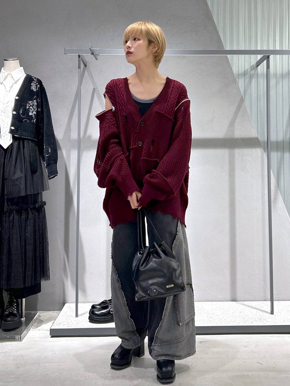 ブラック系のショルダーバッグ、ブラック系のデニムパンツ、ブルー系のタンクトップを着用したレディースの秋コーディネートの7枚目の写真