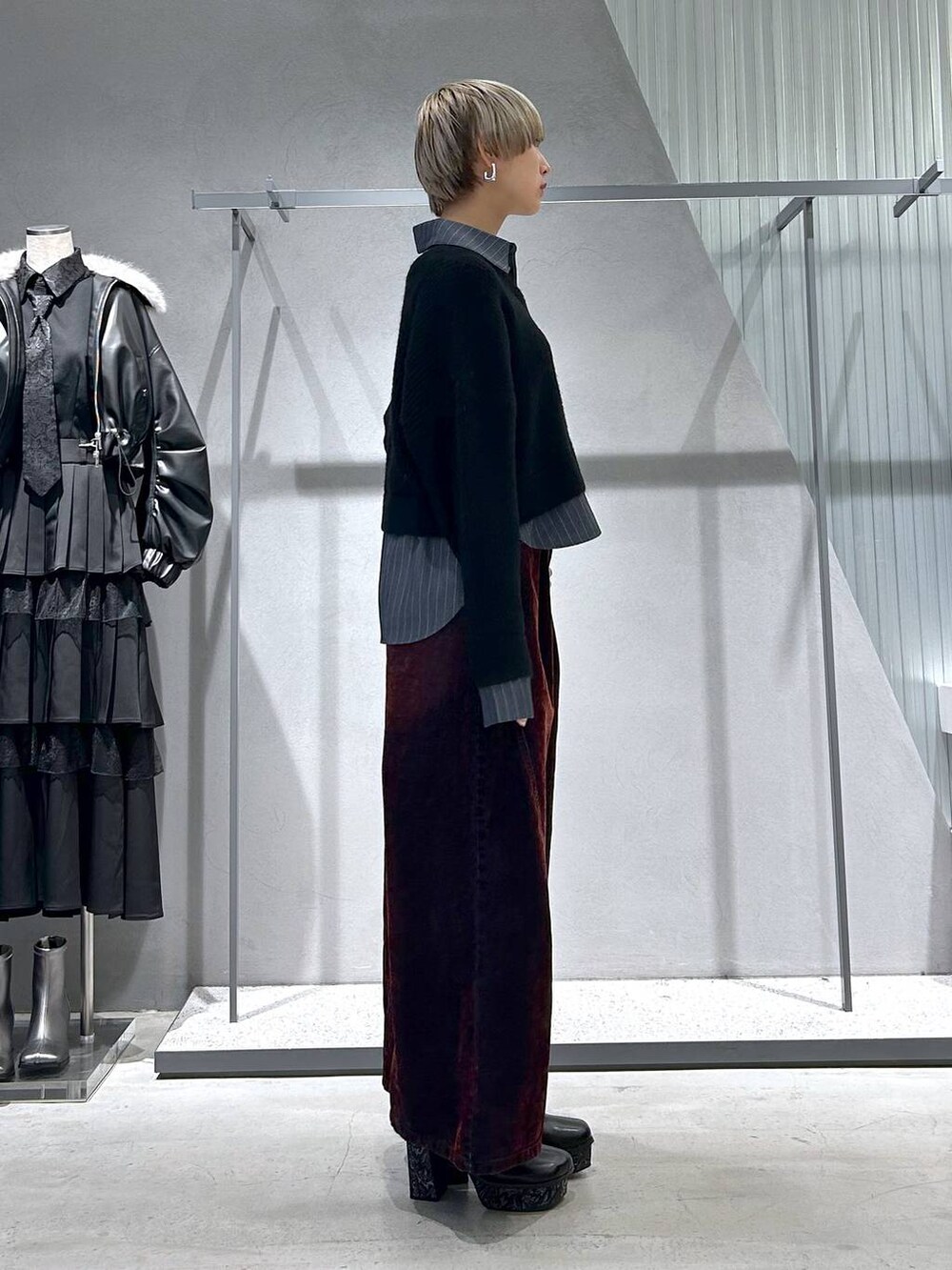 グレー系のチェスターコート、グレー系のブーツ、ブラック系のニット/セーターを着用したレディースの冬コーディネートの6枚目の写真