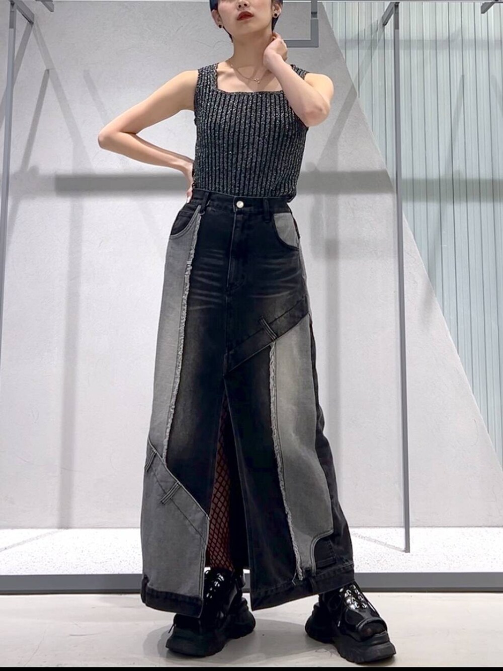 ブラック系のタンクトップ、ブラック系のサンダル、ブラック系のデニムスカートを着用したレディースの春コーディネートの2枚目の写真