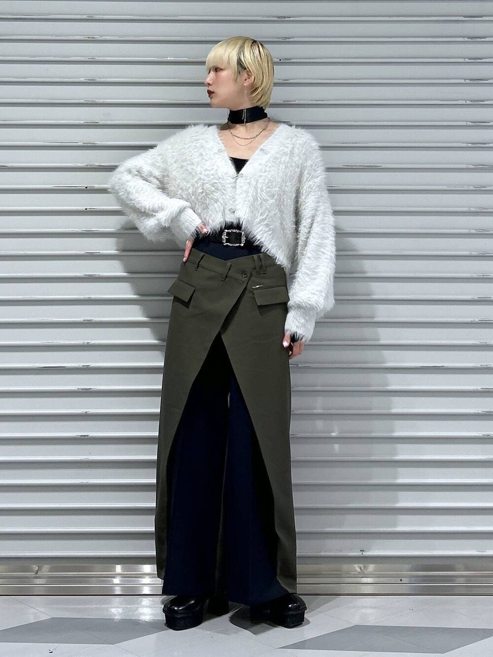 グレー系のブーツ、グレー系のカーディガン/ボレロ、グリーン系のスラックスを着用したレディースの冬コーディネートの3枚目の写真