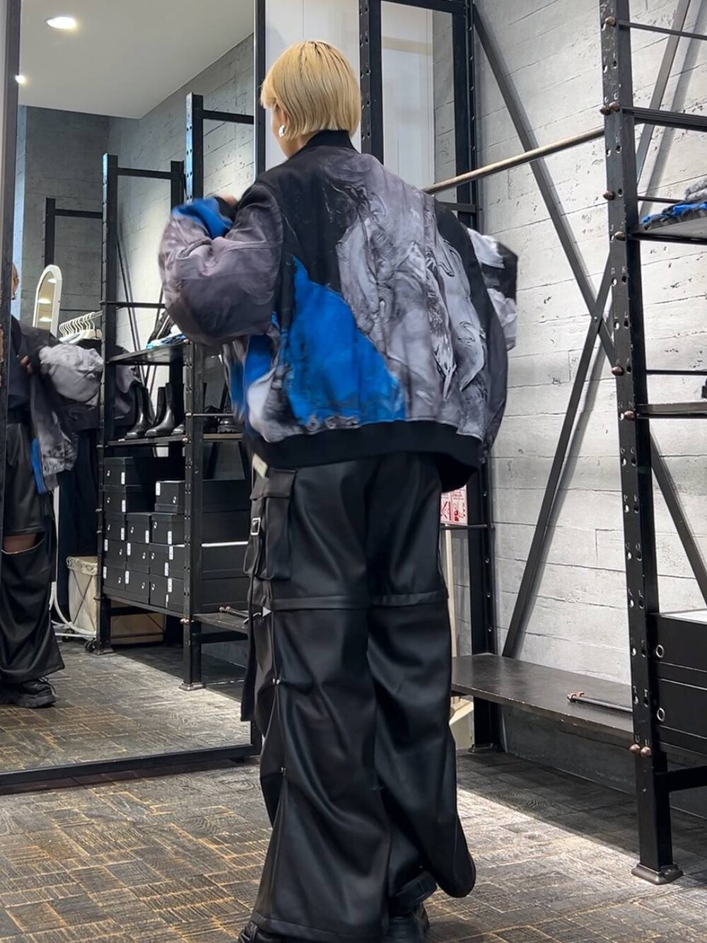 ブラック系のカーゴパンツ、ブラック系のサンダル、ブルー系のシャツ/ブラウスを着用したレディースの秋コーディネートの3枚目の写真