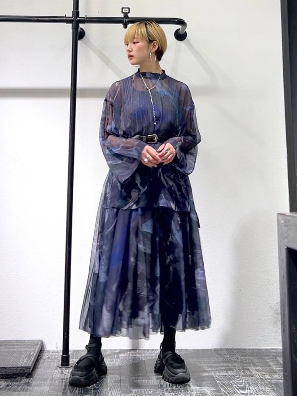 グレー系のタンクトップ、ブラック系のスニーカー、パープル系のシャツ/ブラウスを着用したレディースの春コーディネートの2枚目の写真