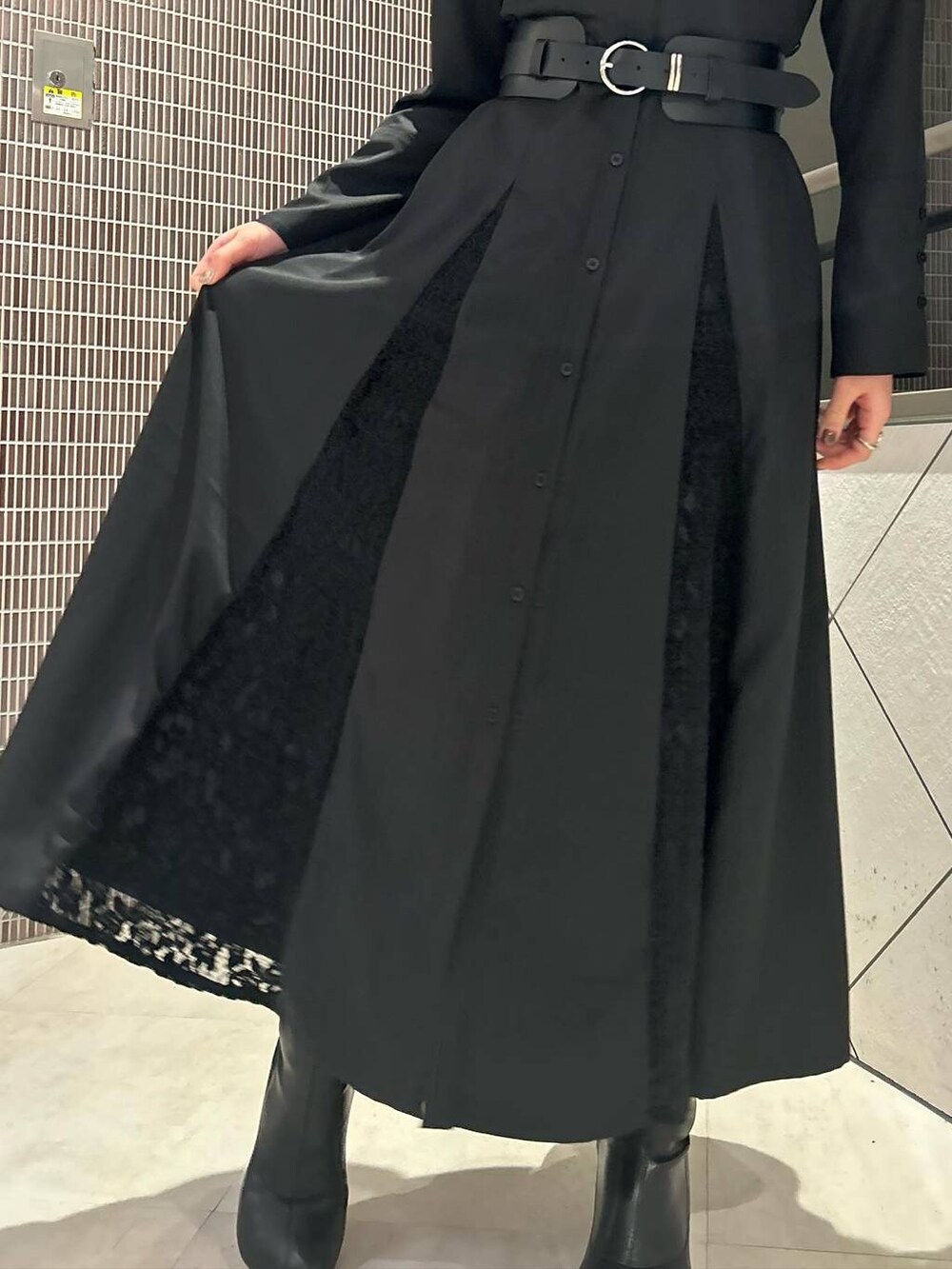 ブラック系のワンピース、ブラック系のブーツ、ブラック系のベルトを着用したレディースの春コーディネートの5枚目の写真