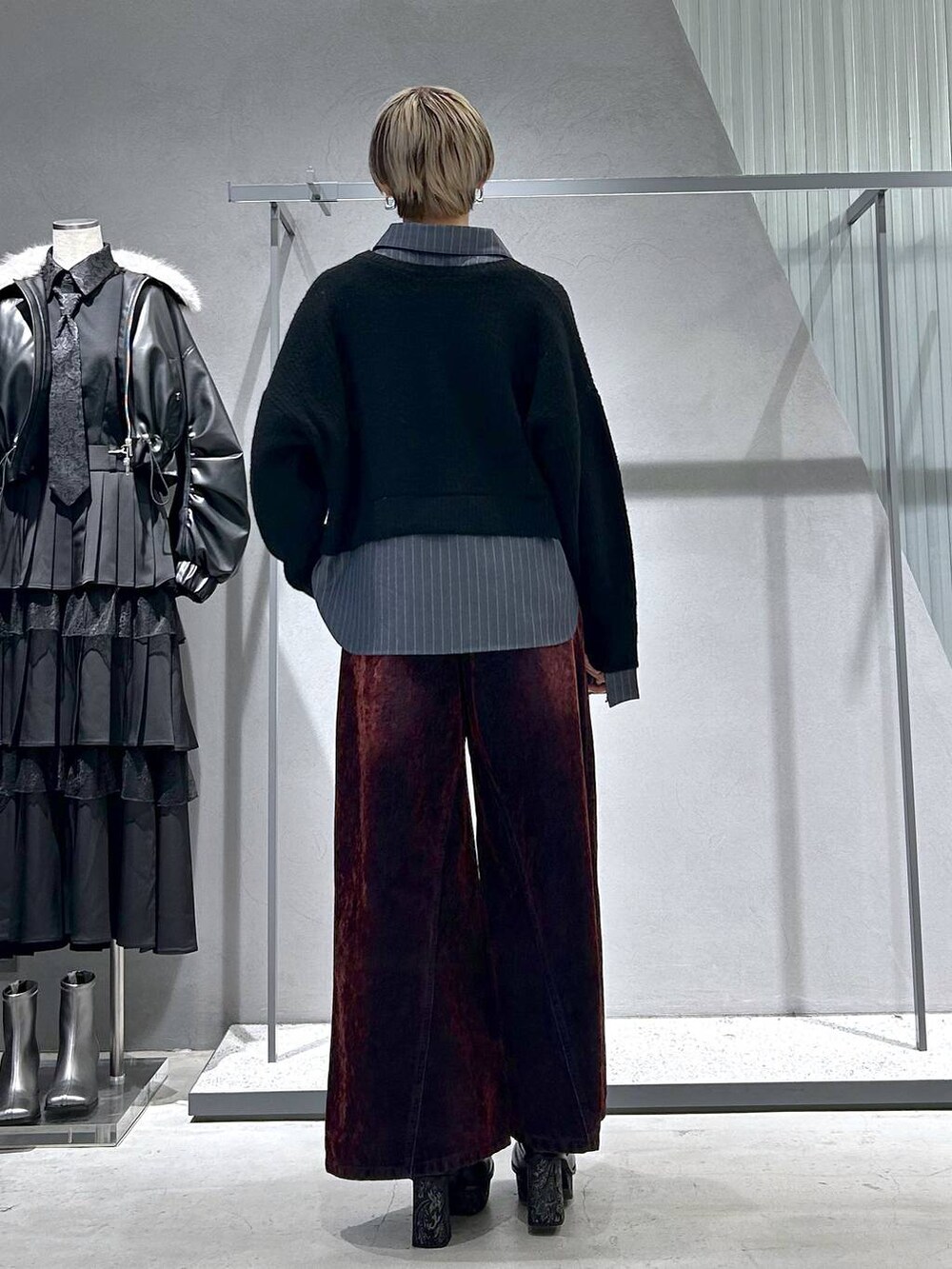 グレー系のチェスターコート、グレー系のブーツ、ブラック系のニット/セーターを着用したレディースの冬コーディネートの7枚目の写真