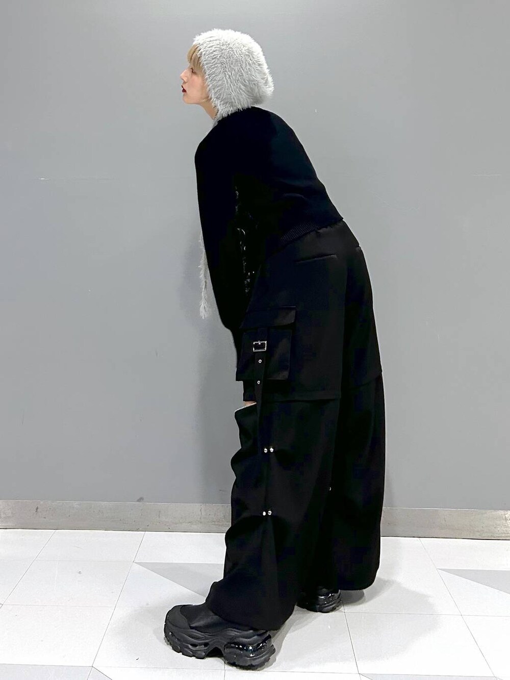 グレー系のTシャツ/カットソー、ブラック系のカーゴパンツ、ブラック系のブーツを着用したレディースの冬コーディネートの2枚目の写真