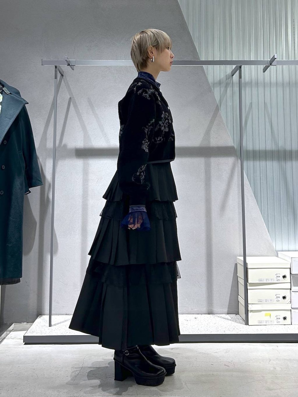 パープル系のTシャツ/カットソー、グレー系のブーツ、ブラック系のスカートを着用したレディースの冬コーディネートの5枚目の写真