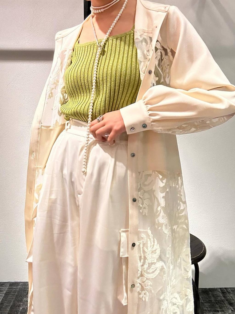 イエロー系のタンクトップ、ブラック系のサンダル、ホワイト系のワンピースを着用したレディースの春コーディネートの2枚目の写真