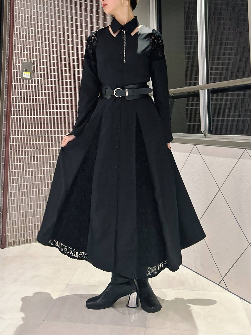 ブラック系のワンピース、ブラック系のブーツ、ブラック系のベルトを着用したレディースの春コーディネートの4枚目の写真