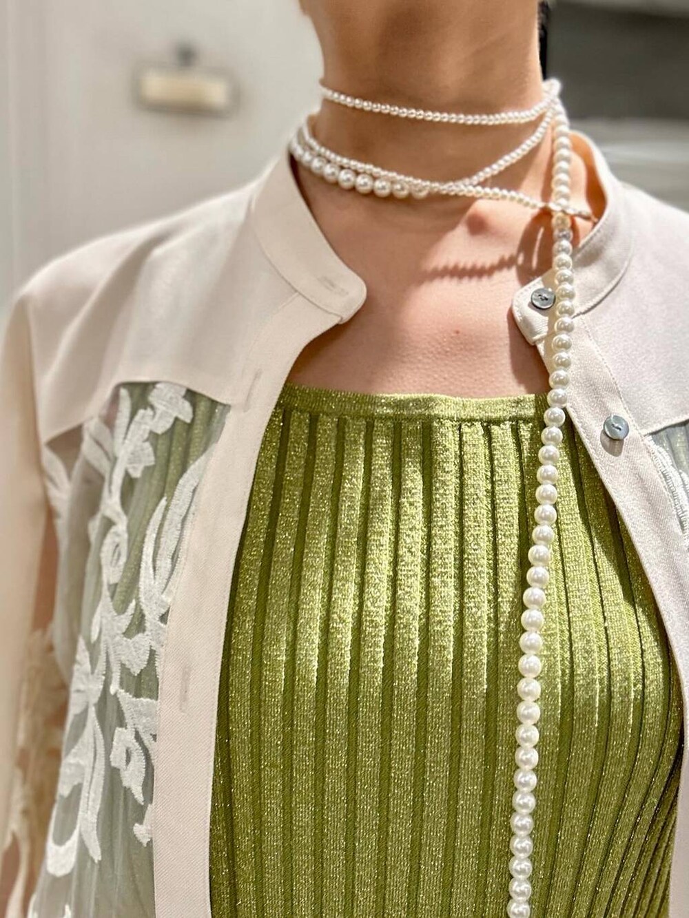 イエロー系のタンクトップ、ブラック系のサンダル、ホワイト系のワンピースを着用したレディースの春コーディネートの3枚目の写真