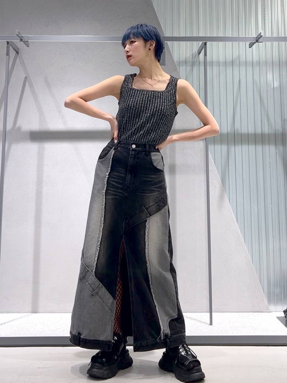 ブラック系のタンクトップ、ブラック系のサンダル、ブラック系のデニムスカートを着用したレディースの春コーディネートの3枚目の写真