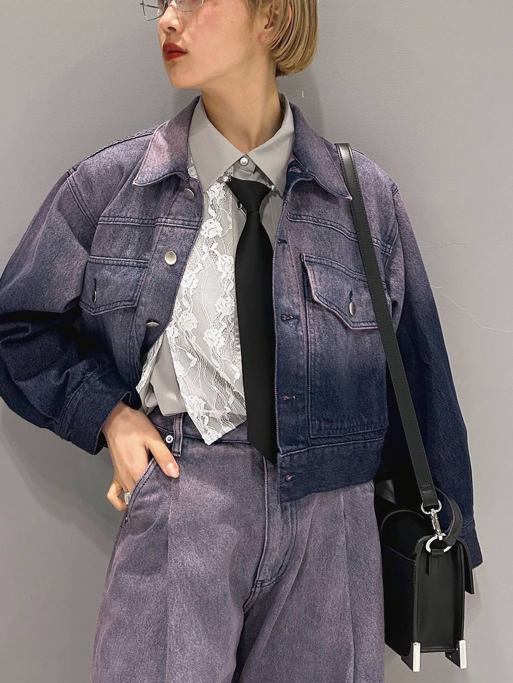 ブラック系のネクタイ、ブラック系のブーツ、ブラック系のショルダーバッグを着用したレディースの冬コーディネートの7枚目の写真