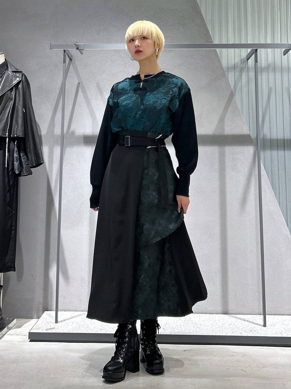 ブラック系のブルゾン、ブラック系のブーツ、グリーン系のスウェットを着用したレディースの秋コーディネートの2枚目の写真