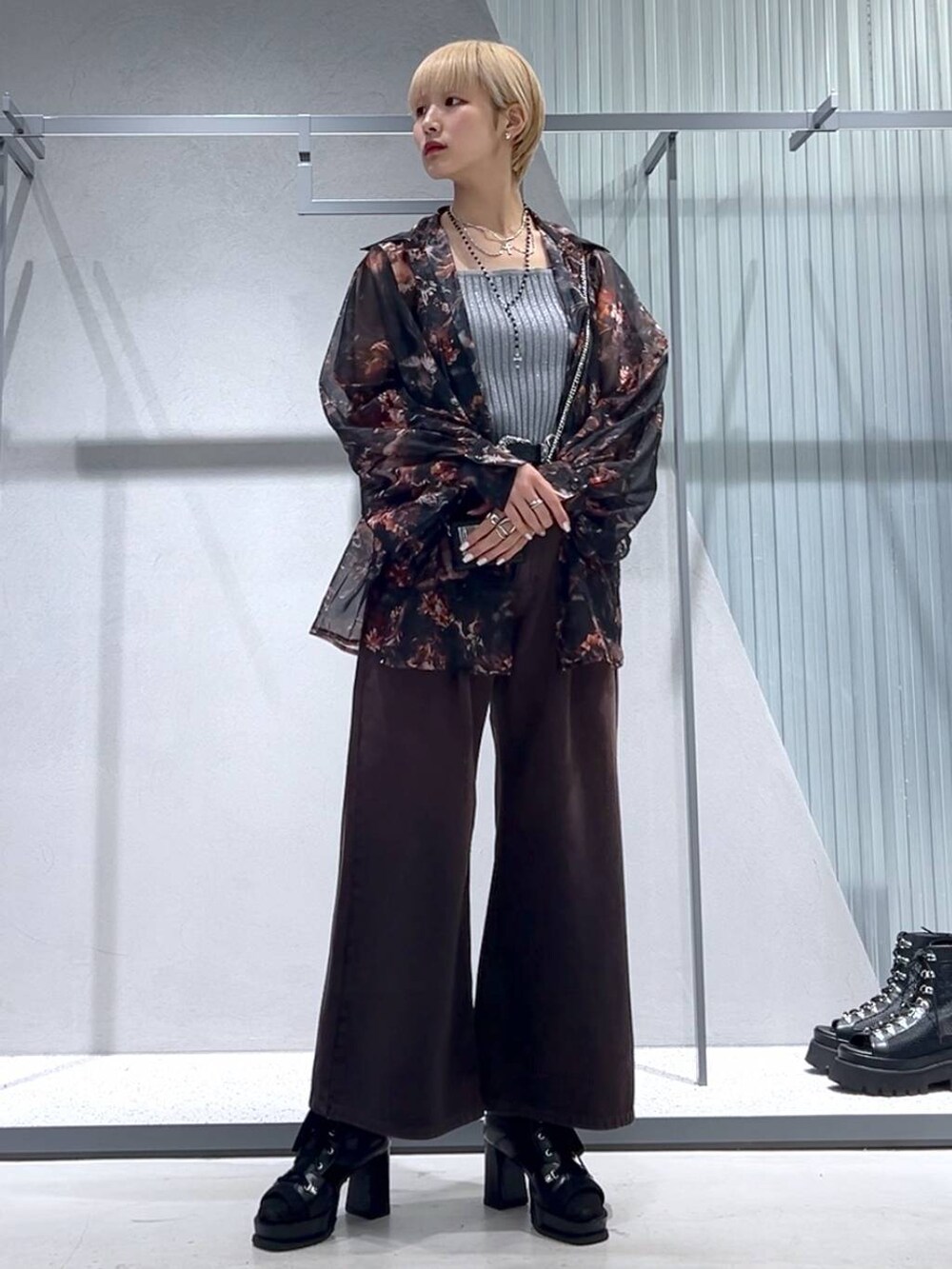 グレー系のタンクトップ、ブラック系のブーツ、オレンジ系のシャツ/ブラウスを着用したレディースの春コーディネートの5枚目の写真