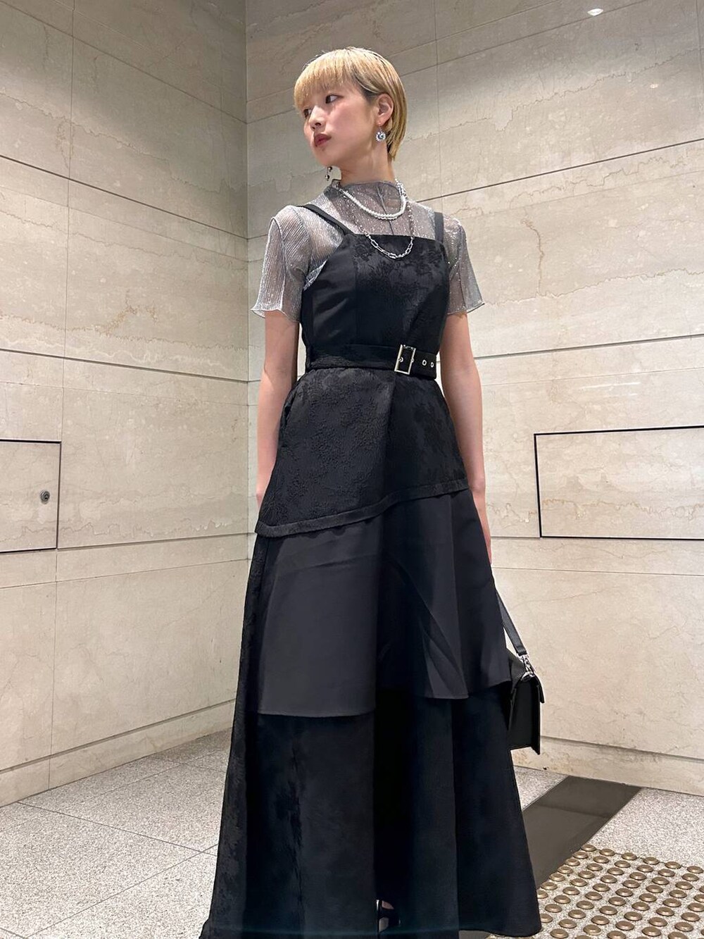 ブラック系のショルダーバッグ、ホワイト系のサンダル、ブラック系のワンピースを着用したレディースの春コーディネートの9枚目の写真