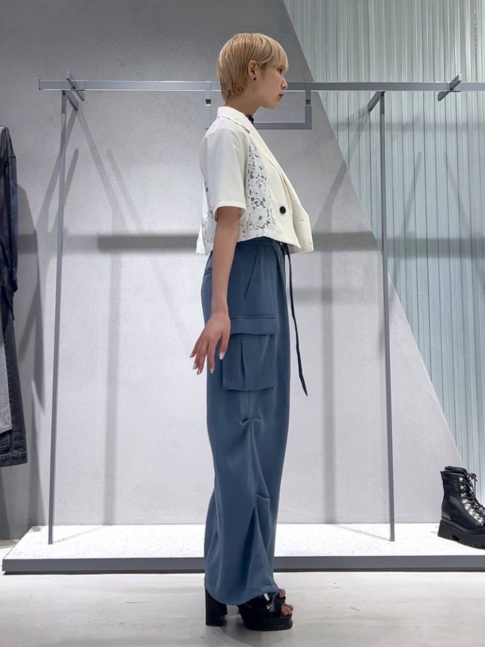 ブルー系のカーゴパンツ、ブラック系のブーツ、ホワイト系のテーラードジャケットを着用したレディースの春コーディネートの8枚目の写真