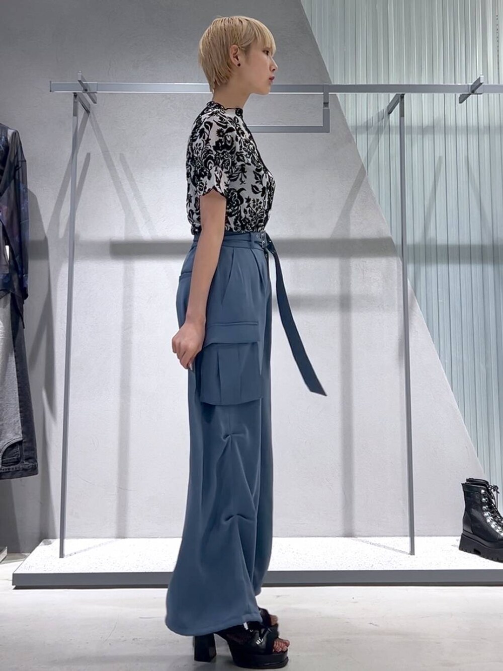 ブルー系のカーゴパンツ、ブラック系のブーツ、ホワイト系のテーラードジャケットを着用したレディースの春コーディネートの2枚目の写真