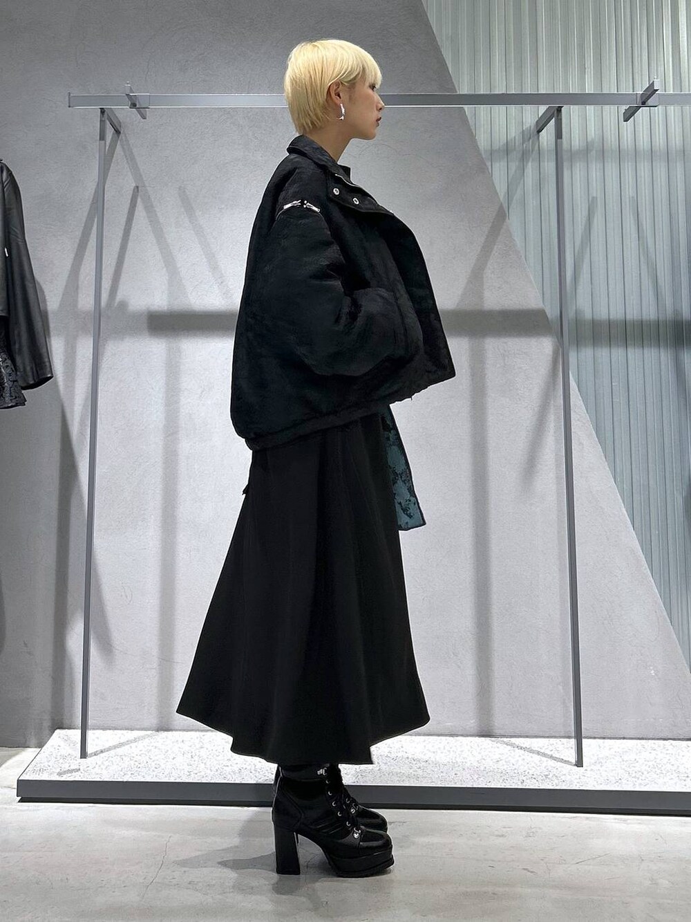 ブラック系のブルゾン、ブラック系のブーツ、グリーン系のスウェットを着用したレディースの秋コーディネートの3枚目の写真